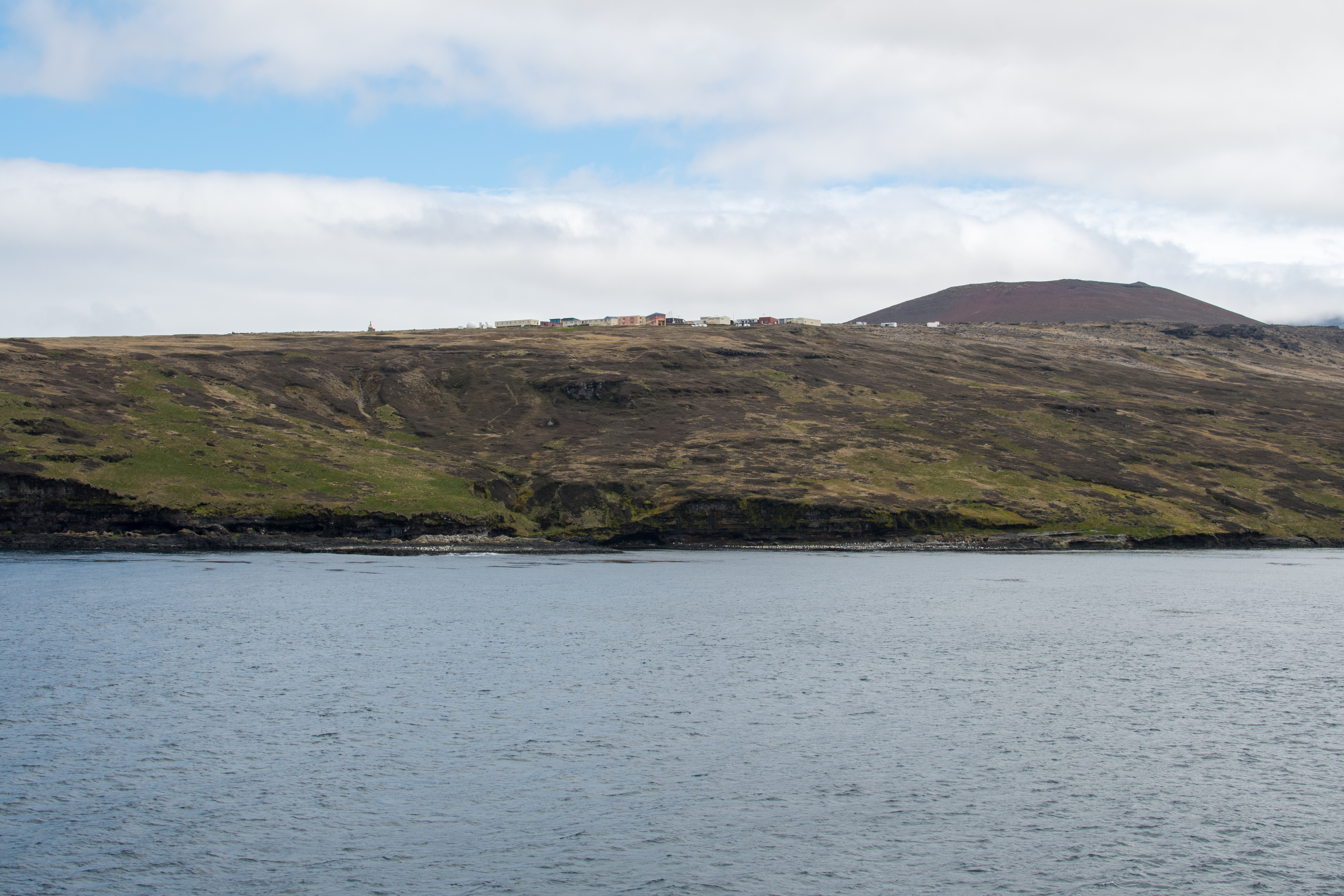 Research station Alfred Faure on Île de la Possession, Crozet Islands, among green slopes and stormy Southern Ocean scenery.