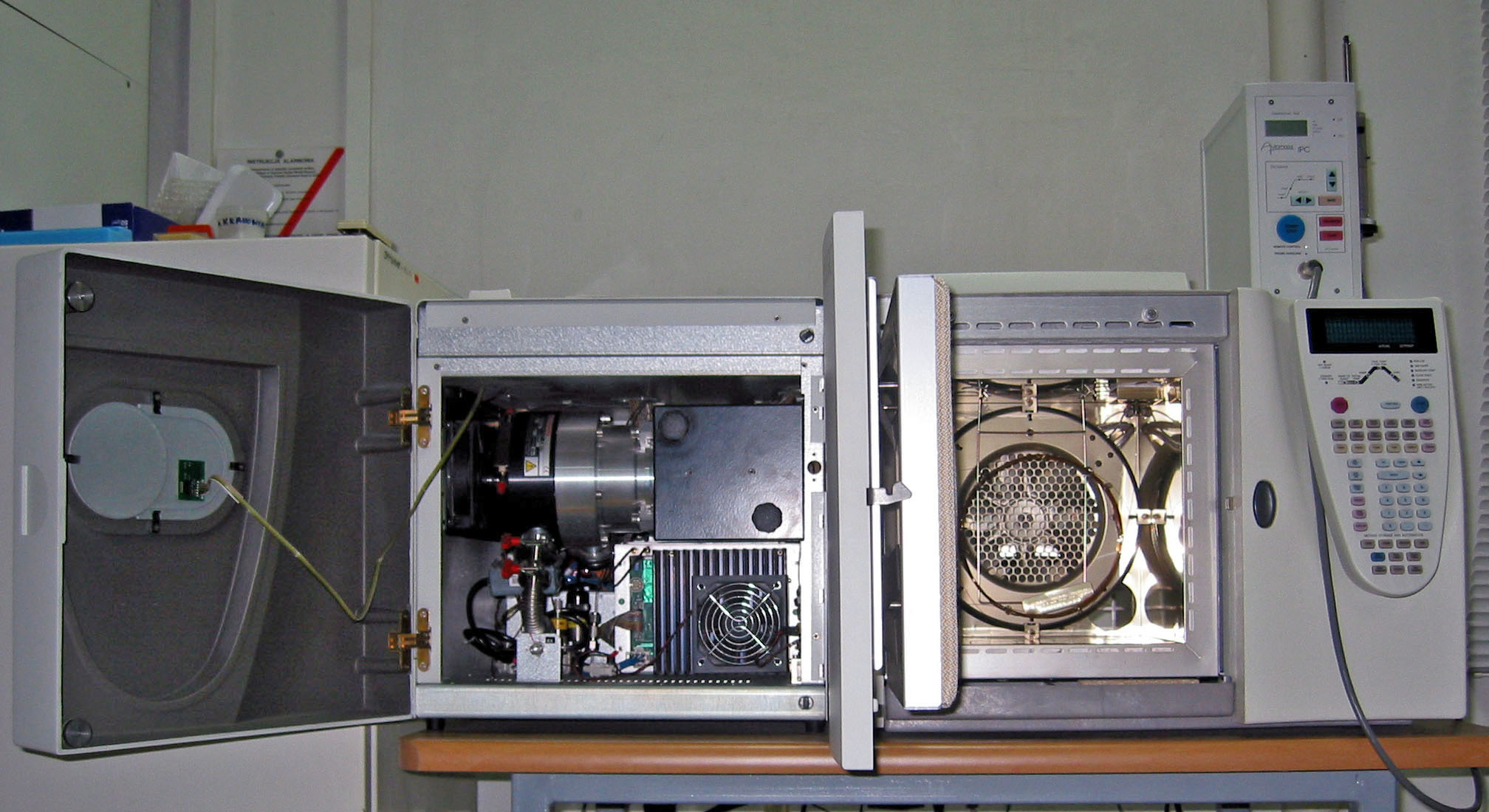 A real laboratory gas chromatograph–mass spectrometer with its doors open, photographed by Polimerek; a general instrument reference, not results from the fictional archaeological exercise.
