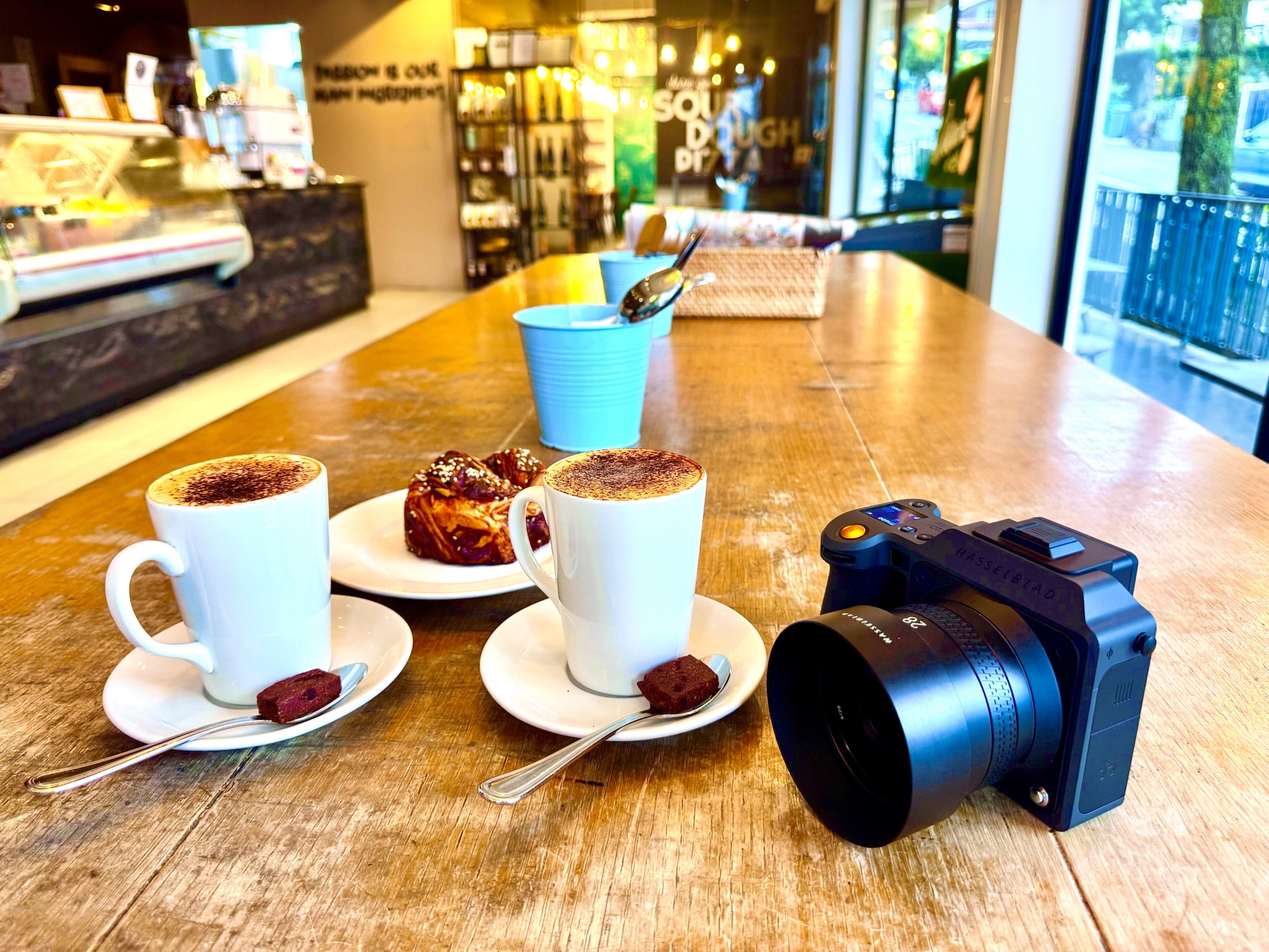 Hasselblad camera with a 28mm lens beside coffee and cakes at a café in Namly, Bukit Timah.