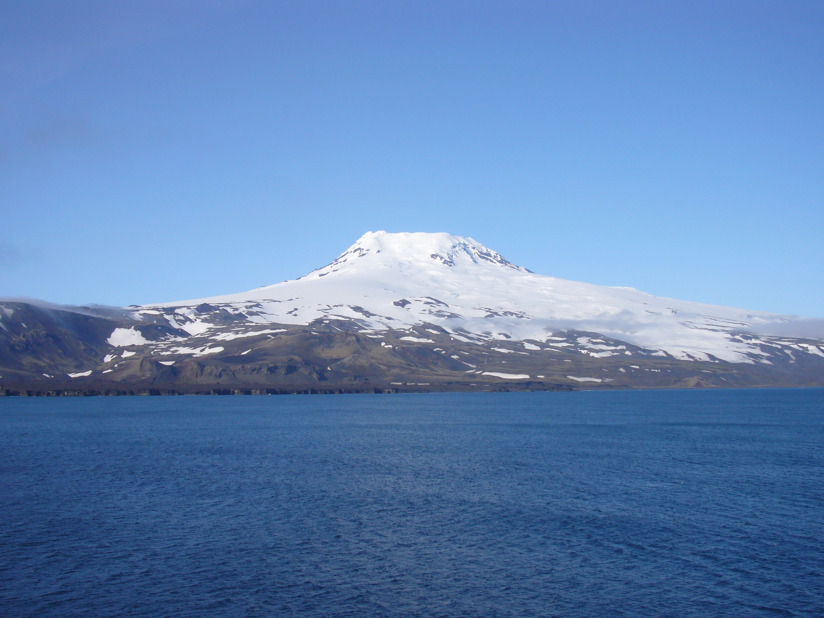 A rare clear view of the snow-covered volcanic Mount Beerenberg on remote Jan Mayen Island, Norway, photographed in 2009.