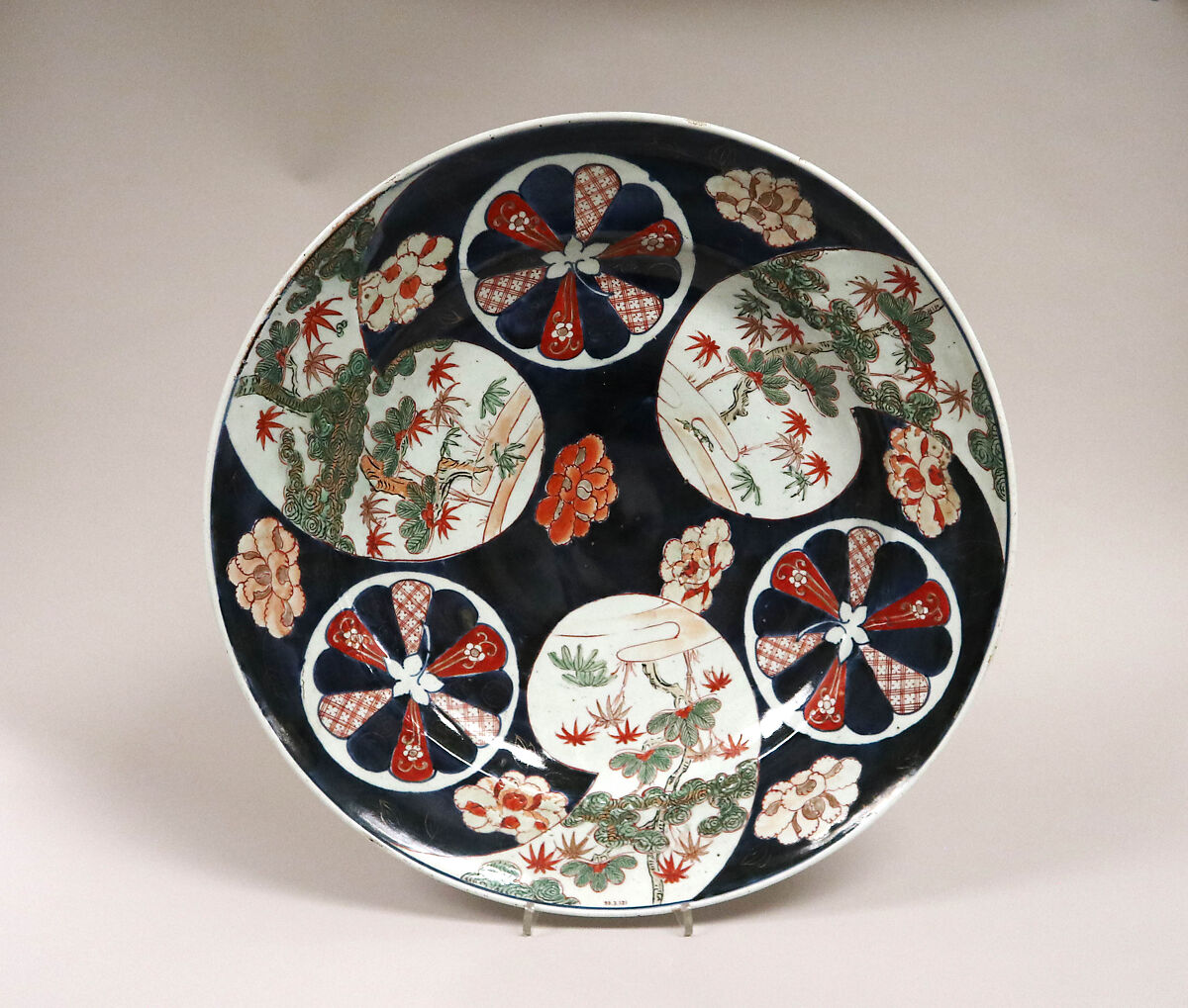 Japanese Arita porcelain dish dated 1720 with dark blue, red, green and gold floral panels; collection of The Metropolitan Museum of Art.