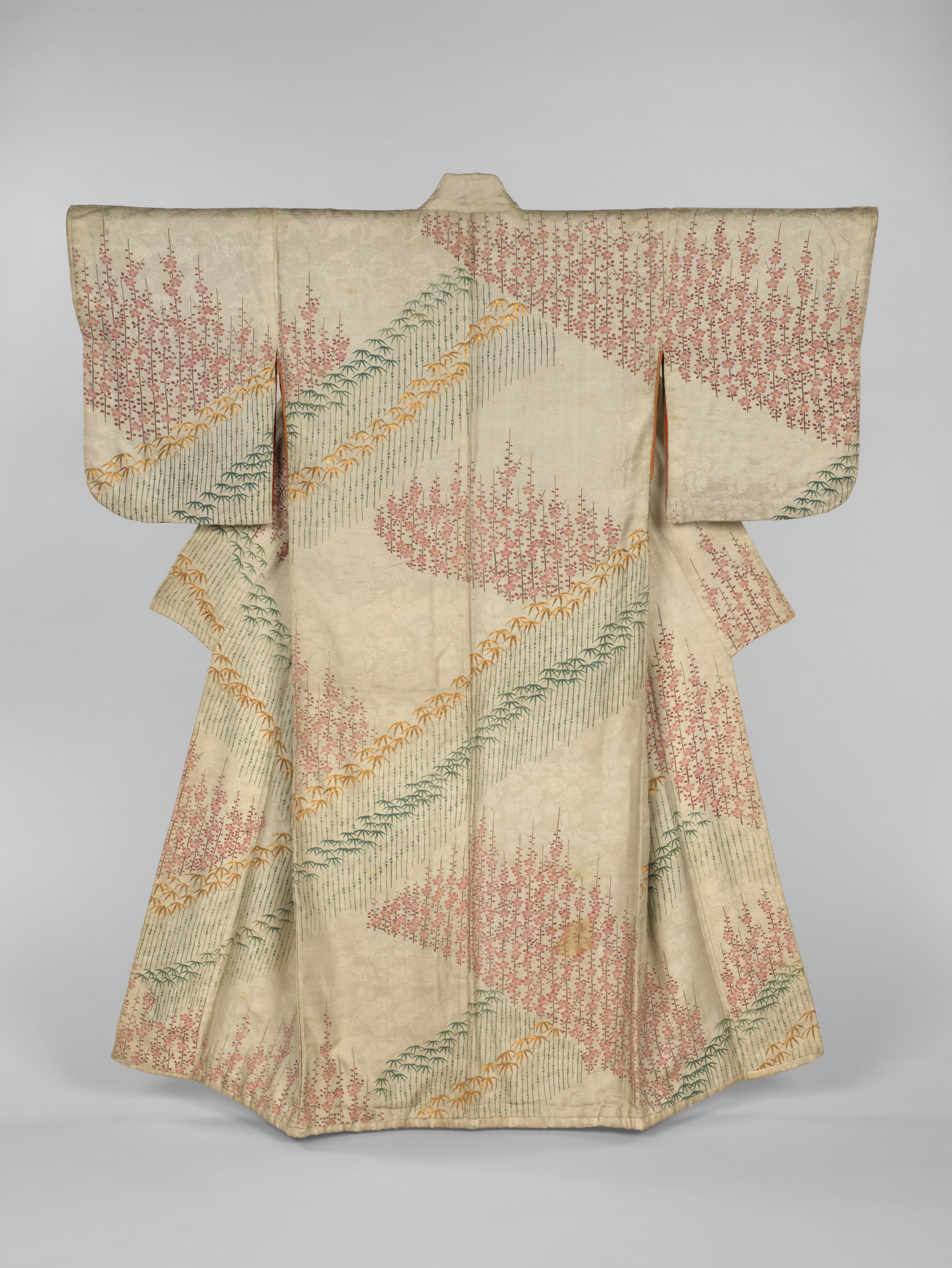 Edo-period Japanese silk kosode with diagonally arranged bamboo and plum blossom motifs on an off-white patterned satin ground.