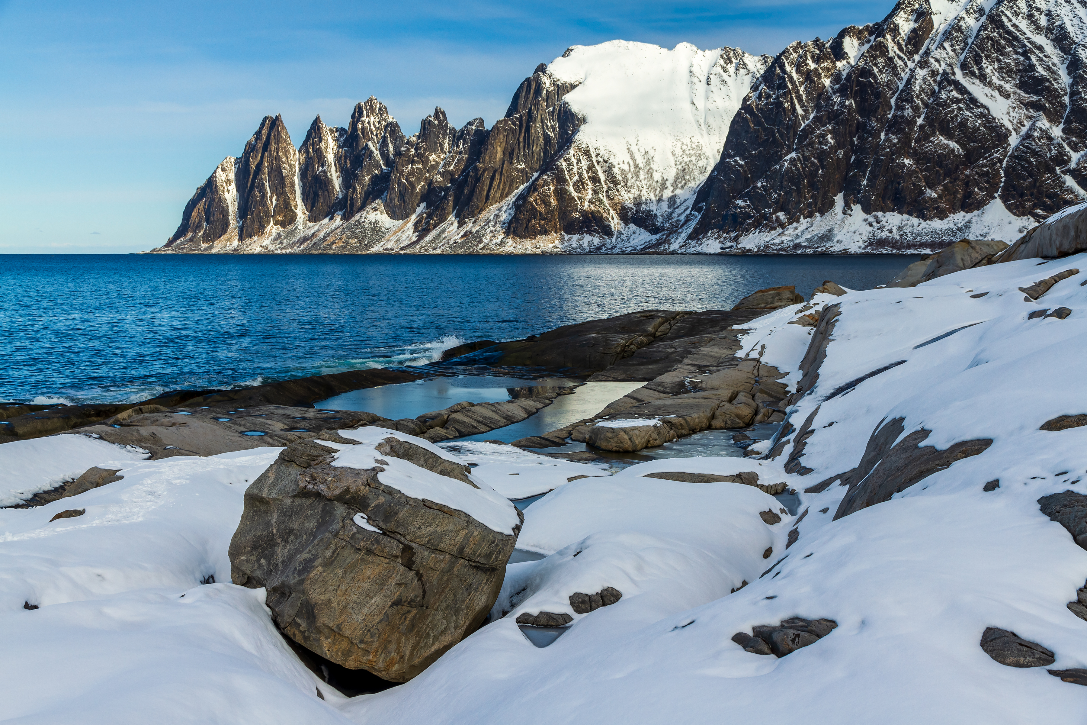 Snow-covered jagged Okshornan mountain peaks across Ersfjorden from Tungeneset on Senja, Norway
