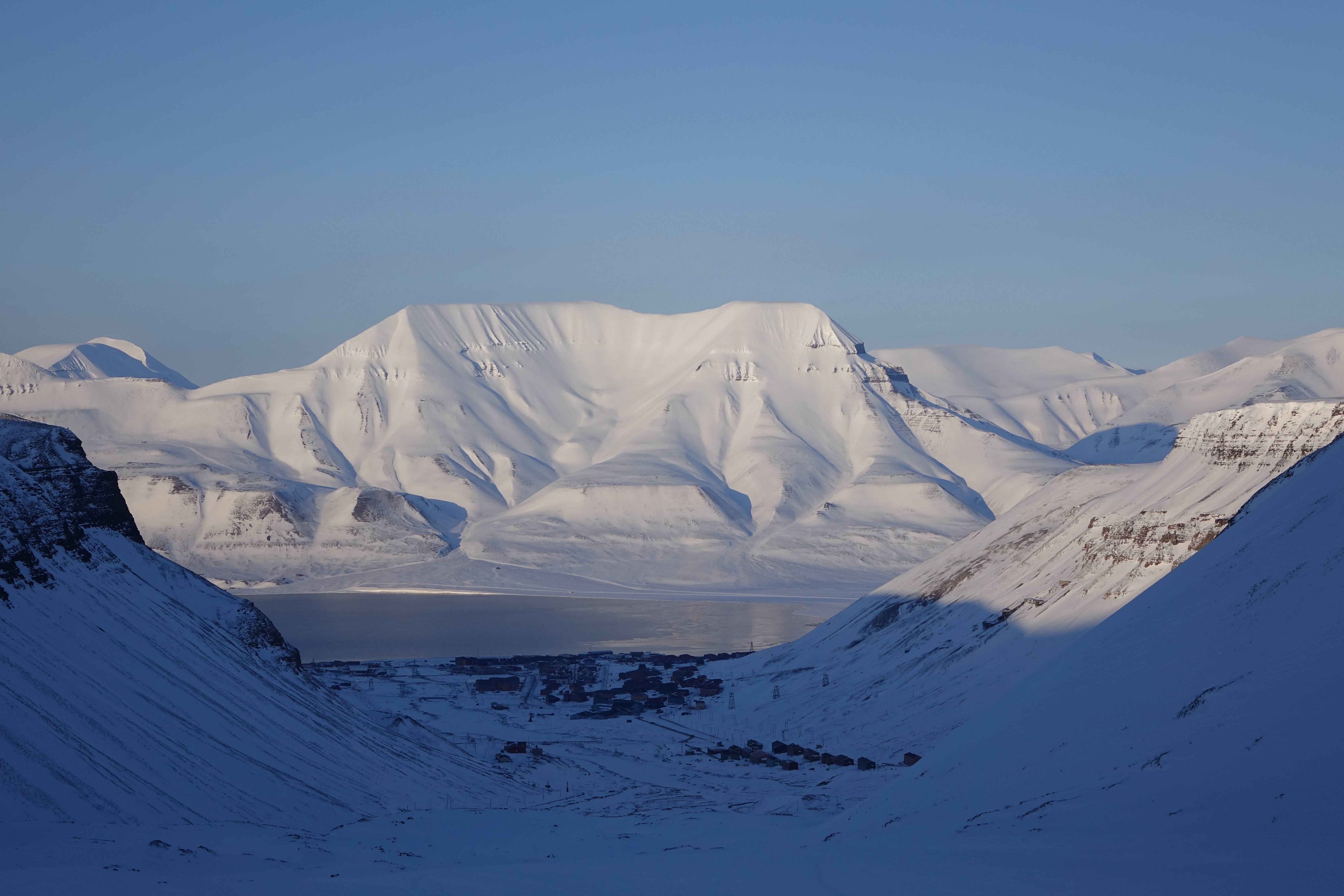 The high Arctic settlement of Longyearbyen beneath snow-covered mountains and the fjord in Svalbard, photographed in April 2016.
