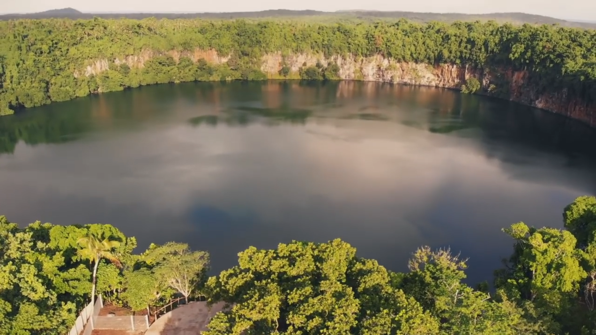Aerial view of the round volcanic Lake Lalolalo surrounded by rainforest on Wallis Island, Wallis and Futuna.